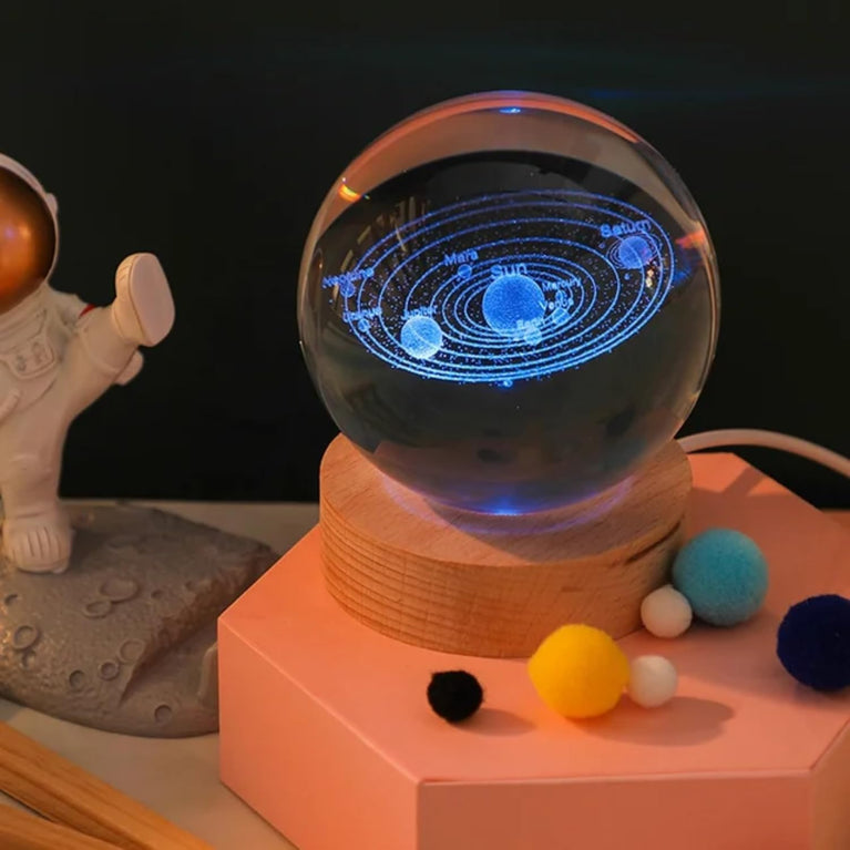 The Snoogg 3D Art Display crystal ball showcases a 3D in a crystal ball, illuminated by a colourful RGB light base (remote included) on a 3.5" wood stand. (Design-Solar System)